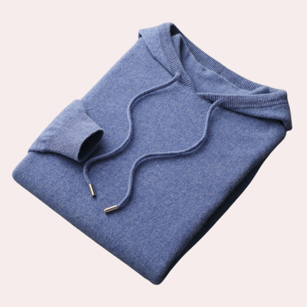 Blauwe gebreide hoodie met capuchon en trekkoorden, opgevouwen op een lichte achtergrond. Comfortabele herenkleding, casual stijl.