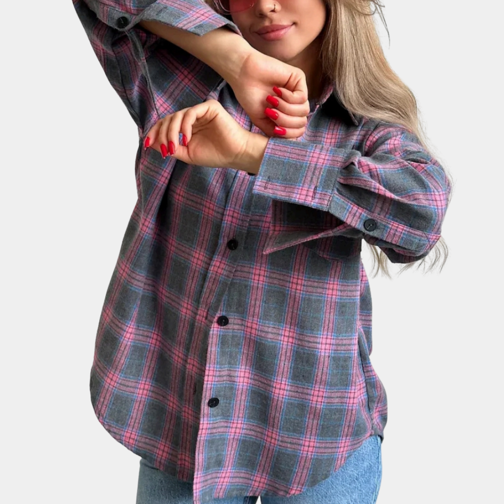 Vrouw in oversized geruite blouse met roze en blauwe tinten, gecombineerd met zwarte jeans. Modieuze casual outfit, trendy dameskleding.